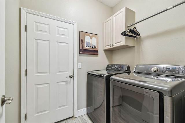 laundry room with washing machine and dryer and cabinets