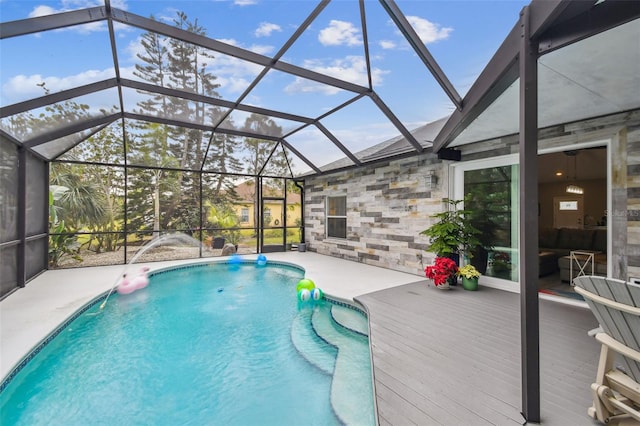 view of swimming pool with a patio area and a lanai