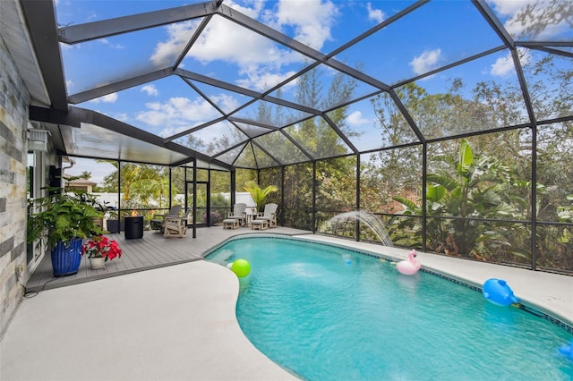 view of pool with glass enclosure and a patio area