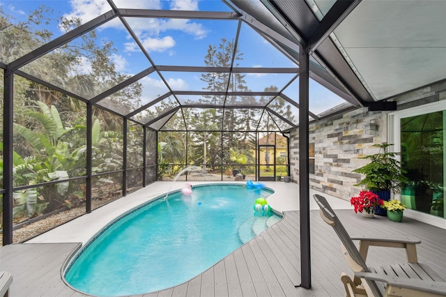 view of swimming pool with glass enclosure and pool water feature