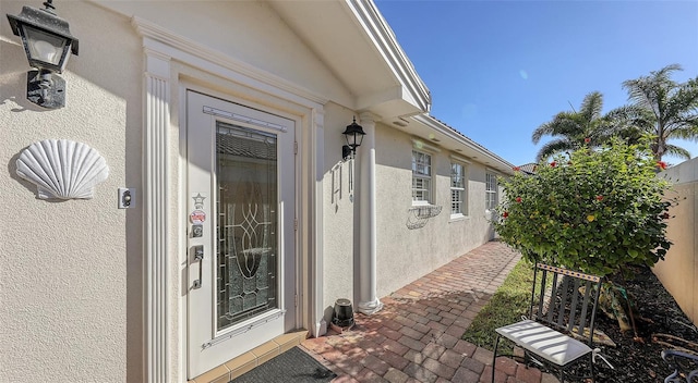 view of exterior entry with a patio