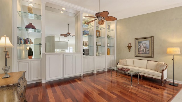 living area featuring ceiling fan, built in features, dark hardwood / wood-style floors, and ornamental molding