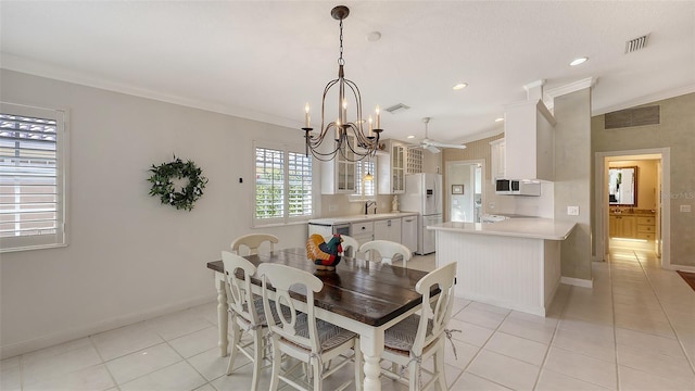 dining space featuring light tile patterned flooring, ornamental molding, sink, and an inviting chandelier