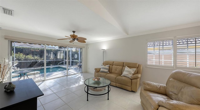 tiled living room with ceiling fan, plenty of natural light, and ornamental molding