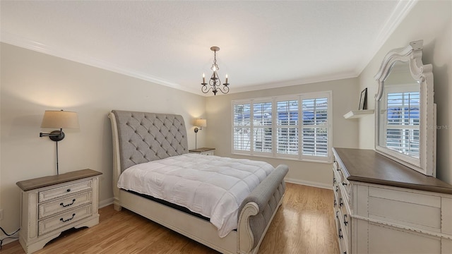 bedroom with light wood-type flooring, crown molding, and an inviting chandelier