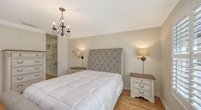 bedroom featuring a closet, light hardwood / wood-style flooring, multiple windows, and ornamental molding