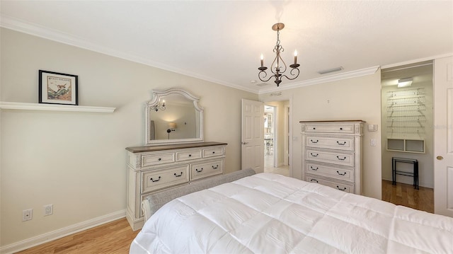 bedroom with an inviting chandelier, light hardwood / wood-style flooring, and crown molding