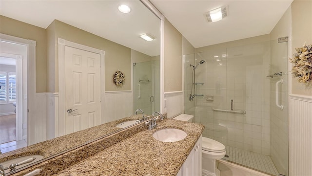 bathroom with toilet, an enclosed shower, and vanity