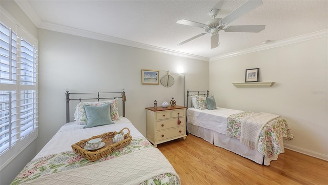 bedroom featuring a textured ceiling, ceiling fan, light wood-type flooring, and crown molding