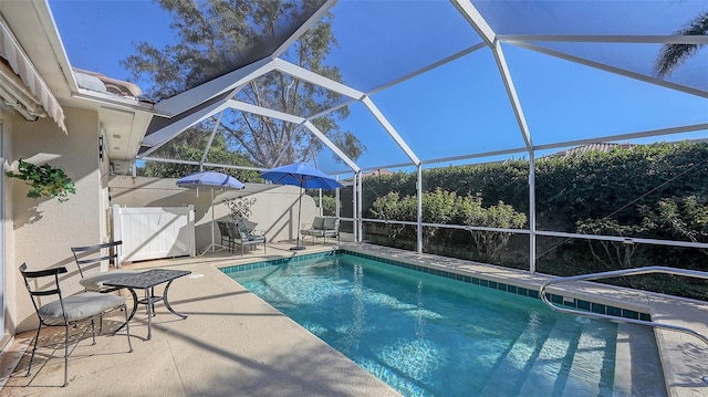 view of swimming pool featuring a patio and glass enclosure