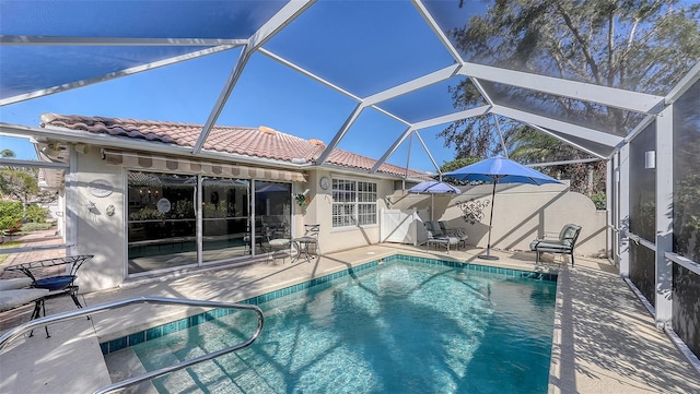 view of swimming pool featuring glass enclosure and a patio area