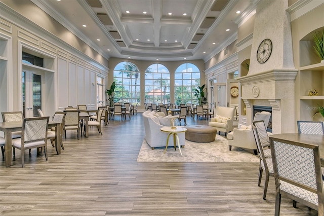 interior space featuring a high ceiling, beam ceiling, crown molding, and a premium fireplace