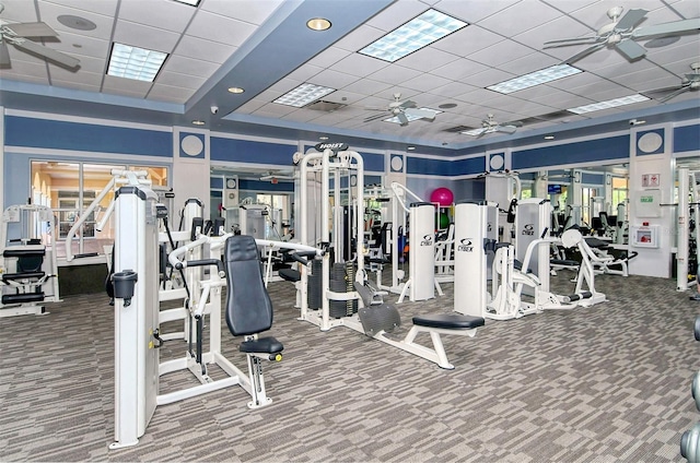 workout area featuring carpet flooring, a drop ceiling, and ceiling fan