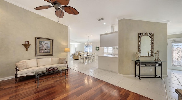 7575 Quinto Dr, Sarasota, FL 34238 - living room with ornamental molding, plenty of natural light, ceiling fan with notable chandelier, and light hardwood / wood-style floors