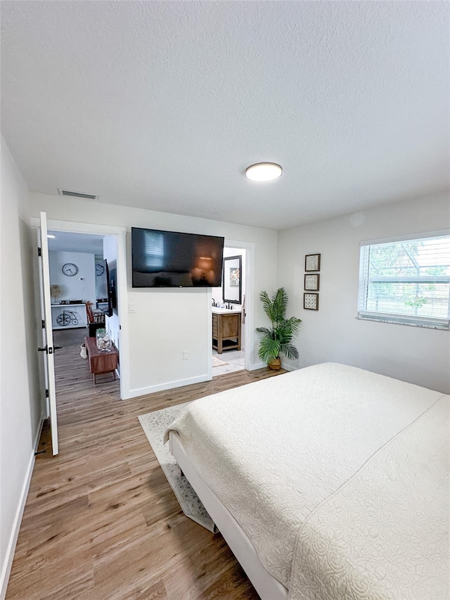 bedroom with wood-type flooring and a textured ceiling