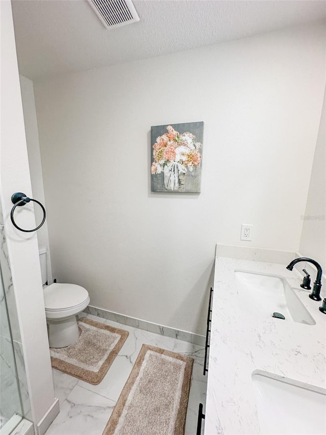 bathroom with vanity, toilet, and a textured ceiling