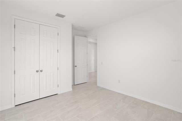 unfurnished bedroom with a closet and light tile patterned floors