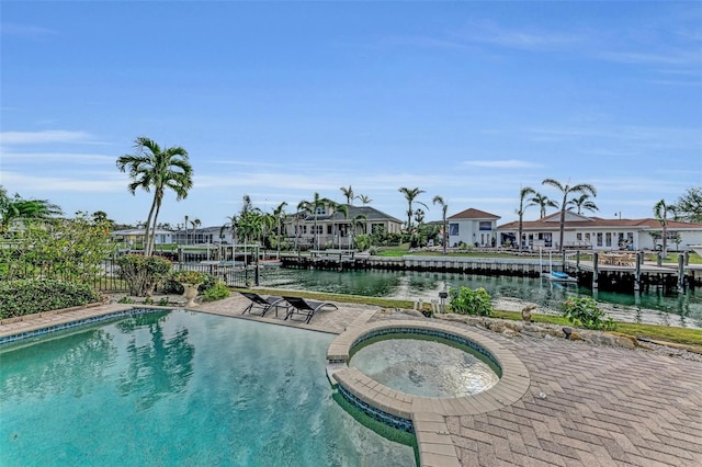 view of swimming pool with an in ground hot tub and a water view