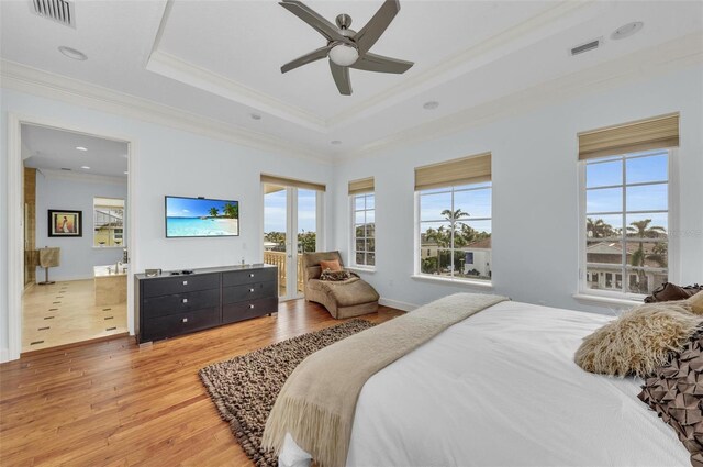 bedroom featuring hardwood / wood-style flooring, ceiling fan, ornamental molding, and a raised ceiling