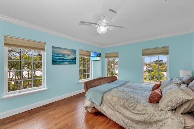 bedroom featuring hardwood / wood-style floors, crown molding, and ceiling fan