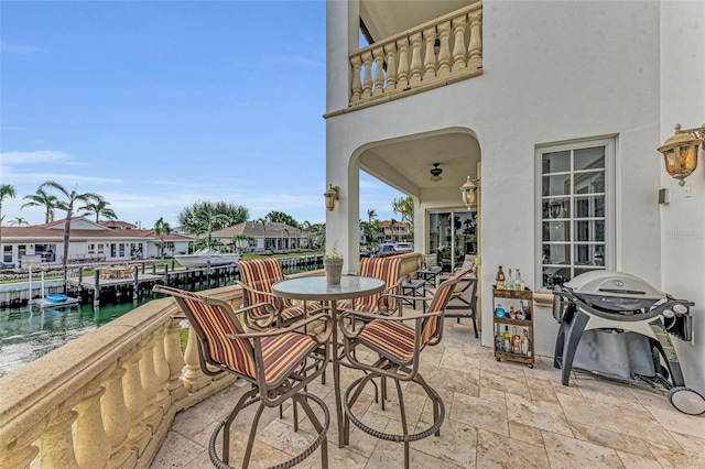 view of patio / terrace with a balcony, a water view, and grilling area