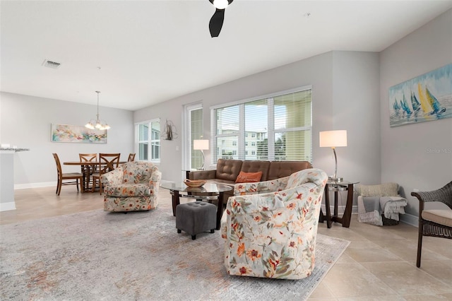 living room with ceiling fan with notable chandelier