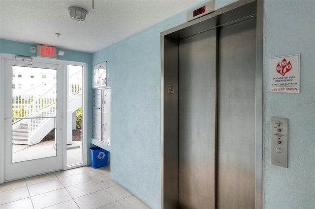 doorway to outside featuring light tile patterned floors and elevator