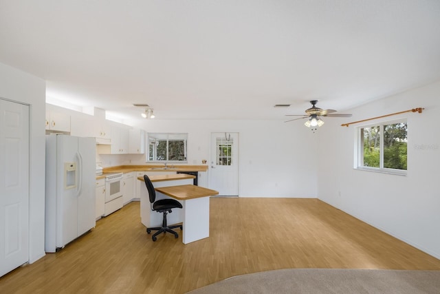 kitchen with white cabinetry, white appliances, light wood-type flooring, a breakfast bar, and sink