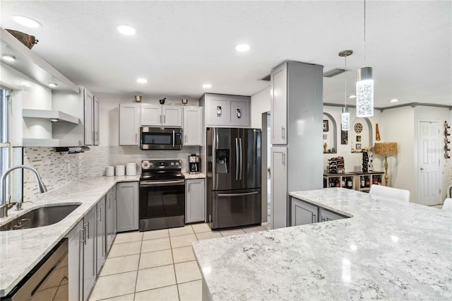 kitchen with sink, light stone counters, hanging light fixtures, gray cabinets, and stainless steel appliances