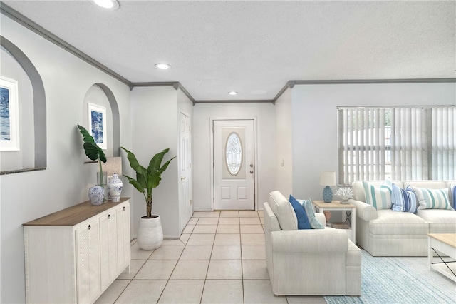 tiled entrance foyer with crown molding and a textured ceiling