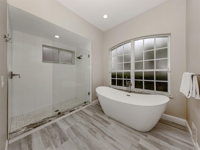 bathroom featuring hardwood / wood-style flooring and independent shower and bath