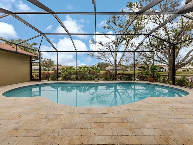 view of pool featuring glass enclosure and a patio area