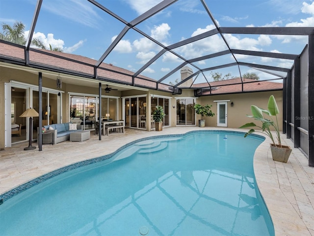 view of swimming pool with glass enclosure, a patio area, an outdoor hangout area, and ceiling fan