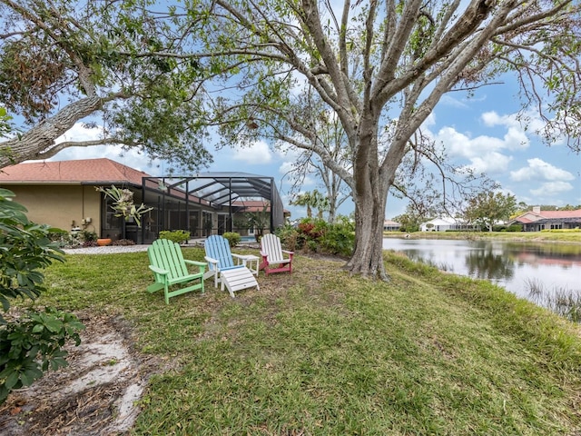 view of yard with a lanai and a water view