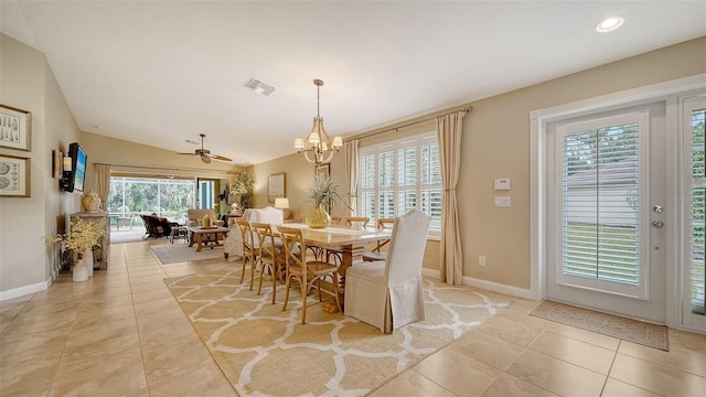 dining area featuring ceiling fan with notable chandelier, plenty of natural light, light tile patterned floors, and vaulted ceiling