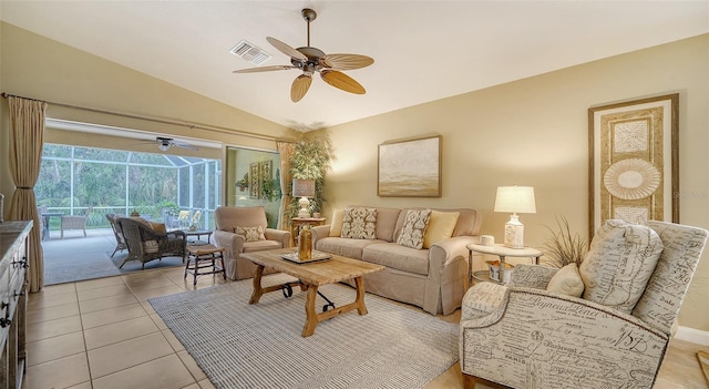 living room with ceiling fan, vaulted ceiling, and light tile patterned flooring