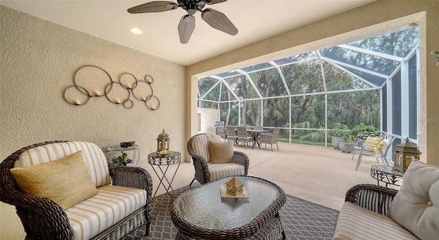 view of patio with ceiling fan, an outdoor hangout area, and glass enclosure