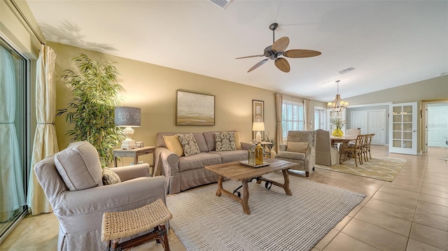 tiled living room with vaulted ceiling and ceiling fan with notable chandelier