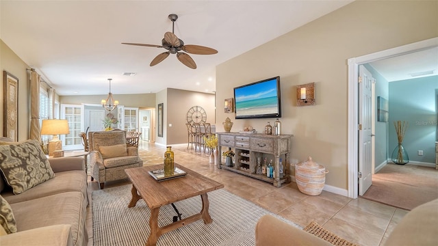 living room featuring vaulted ceiling, light tile patterned flooring, and ceiling fan with notable chandelier