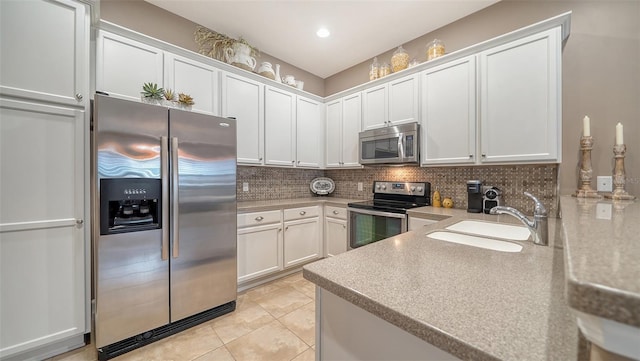 kitchen with light tile patterned floors, white cabinetry, stainless steel appliances, tasteful backsplash, and sink