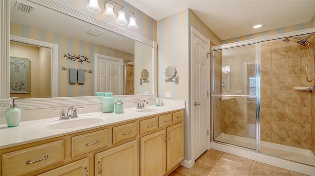 bathroom with tile patterned floors, vanity, and walk in shower