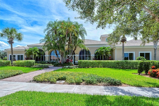 mediterranean / spanish-style house featuring a front lawn