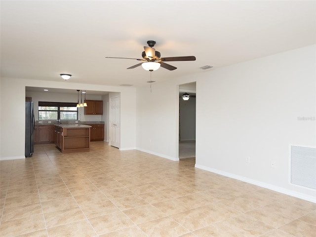 unfurnished living room with ceiling fan and light tile patterned floors