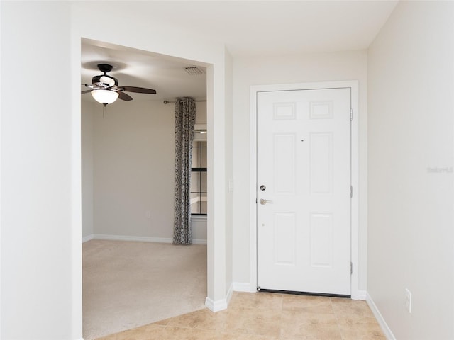 carpeted entryway featuring ceiling fan