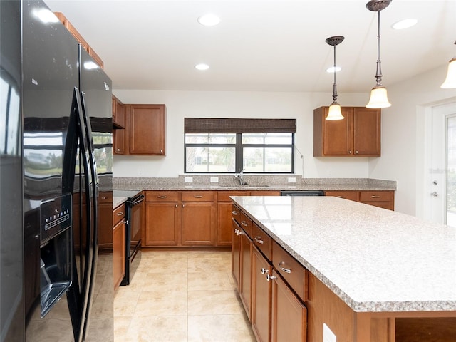 kitchen featuring sink, a kitchen island, black appliances, light tile patterned flooring, and decorative light fixtures