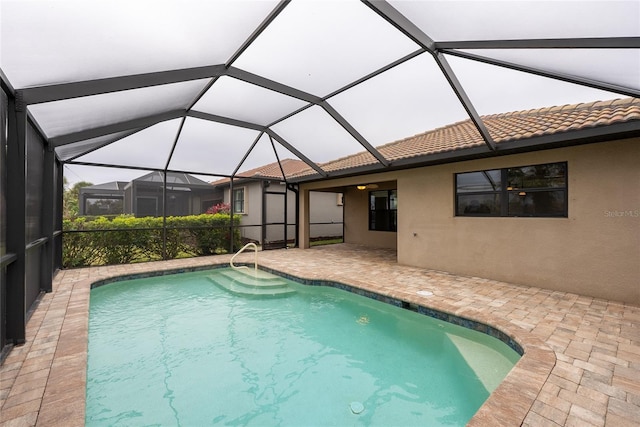 view of pool featuring glass enclosure and a patio area