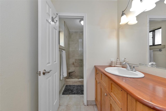 bathroom with tiled shower, vanity, and tile patterned flooring