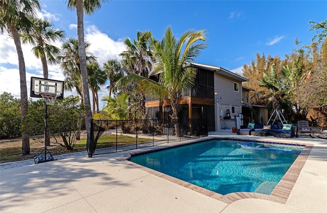 view of swimming pool with a patio area and a sunroom