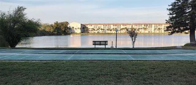 surrounding community featuring a lawn and a water view