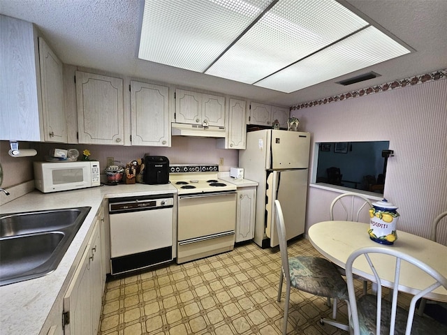 kitchen with white appliances, sink, and a textured ceiling